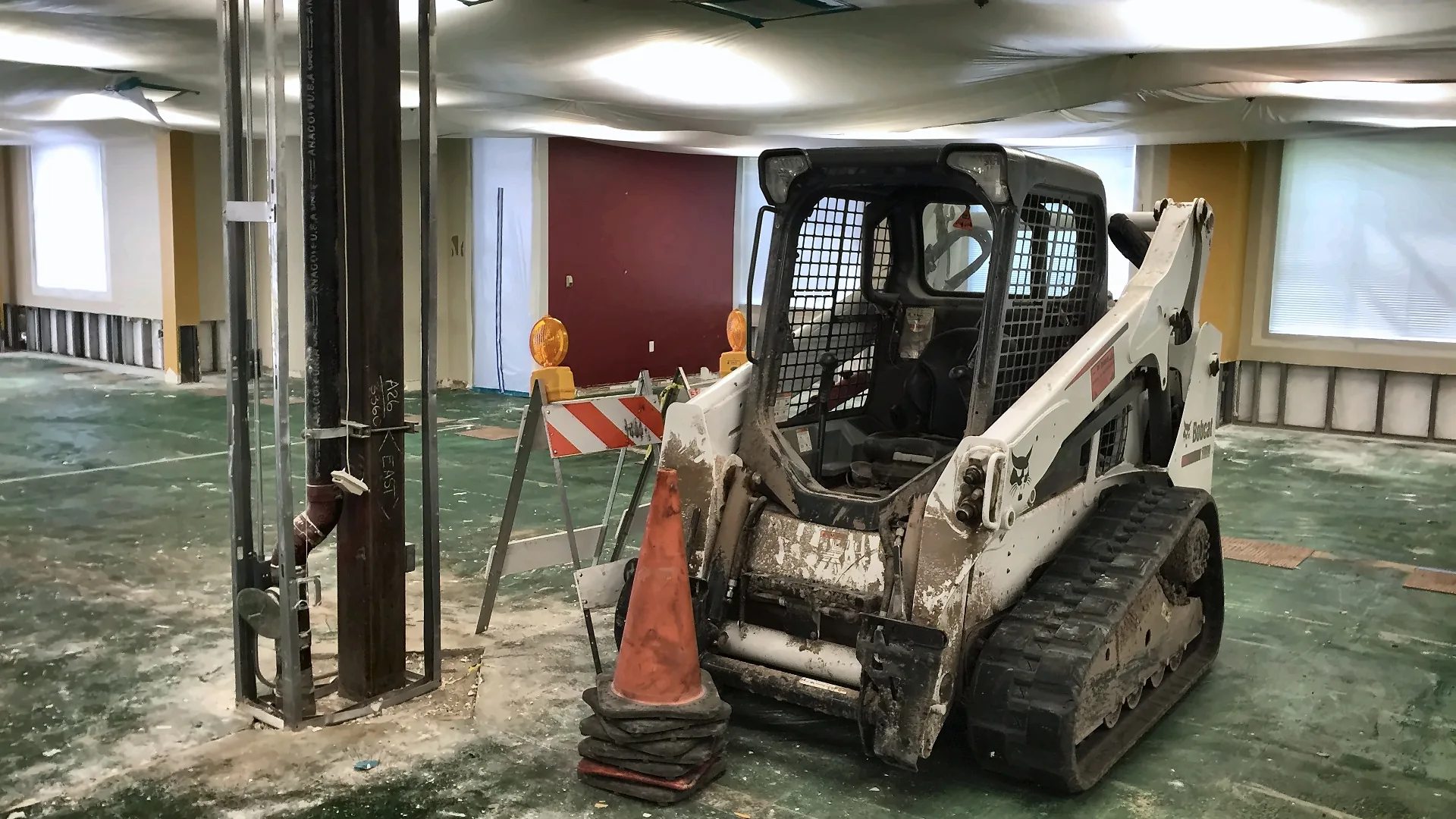 Skid steer removing an interior concrete slab in a commercial building